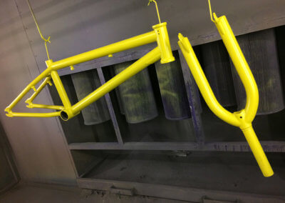 Bicycle parts painted in yellow at Tallaght Powder Coating
