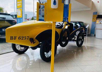 Yellow powder coated hand sanitiser stand with dispenser inside car showroom Dublin